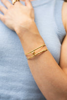 Model wearing first love adjustable bangle cuff in gold