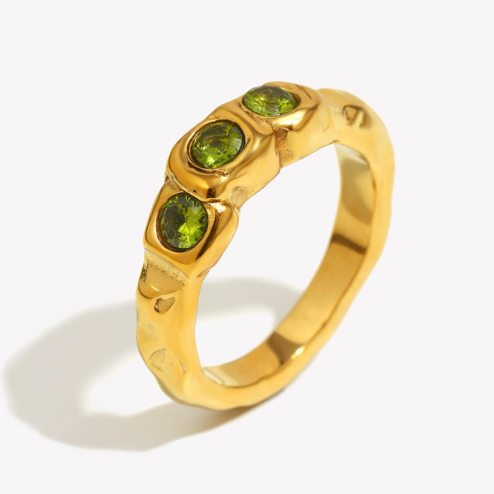 Close up of Mila Online Shop Amalfi Ring in gold with three layered green gemstones, bold chunky ring styled as a modern statement with gold stackable rings.