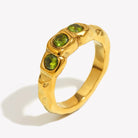 Close up of Mila Online Shop Amalfi Ring in gold with three layered green gemstones, bold chunky ring styled as a modern statement with gold stackable rings.