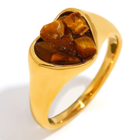 Close up of Mila Online Shop Gemstone Heart Ring in gold with brown heart cut gemstone, bold chunky ring layered with gemstone rings and stackable gold rings