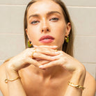 Model wearing vivid green Mia Resin Hoops by Mila Online Shop, styling bangles and rings for a cohesive, fashion-forward jewellery look.