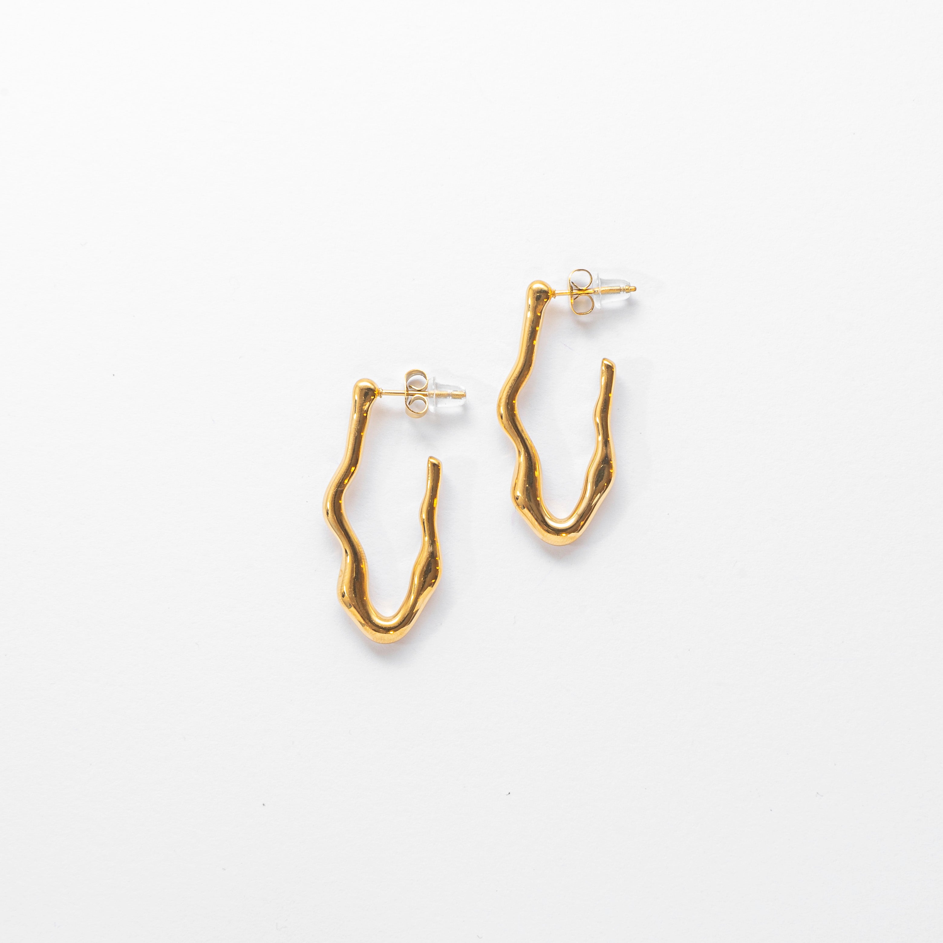 Close up of gold stud earrings — Wave Stud Earrings by Mila Online Shop. Sculptural and minimalist statement studs with a lightweight, waterproof design.