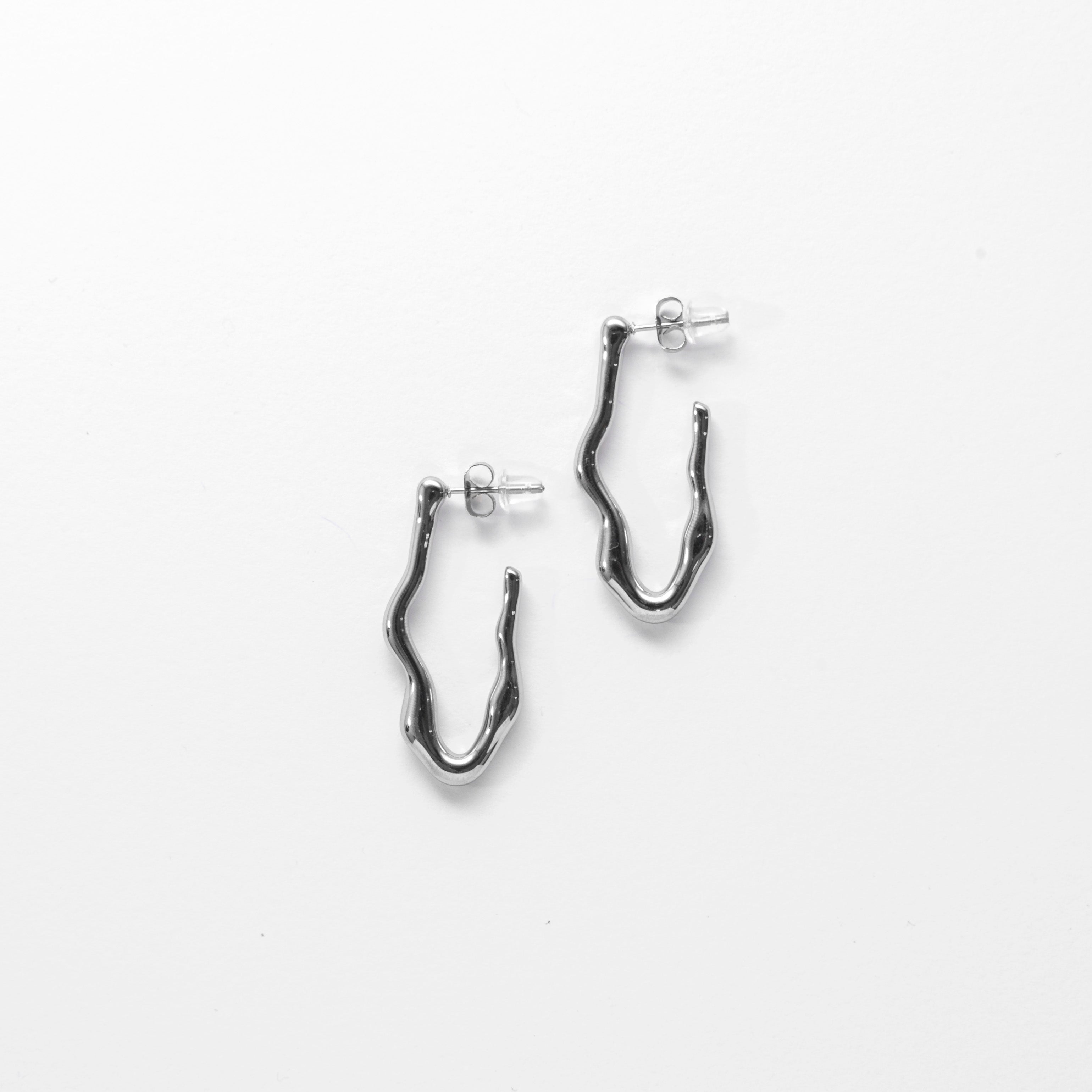 Close up of silver stud earrings — Wave Stud Earrings by Mila Online Shop. Sculptural and minimalist statement studs with a lightweight, waterproof design.