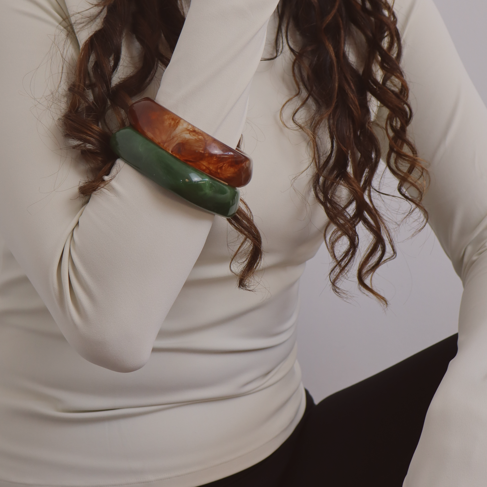 Resin bangles layered together creating sculptural stack