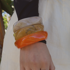 Stacked resin bangles in vibrant tones on model hand