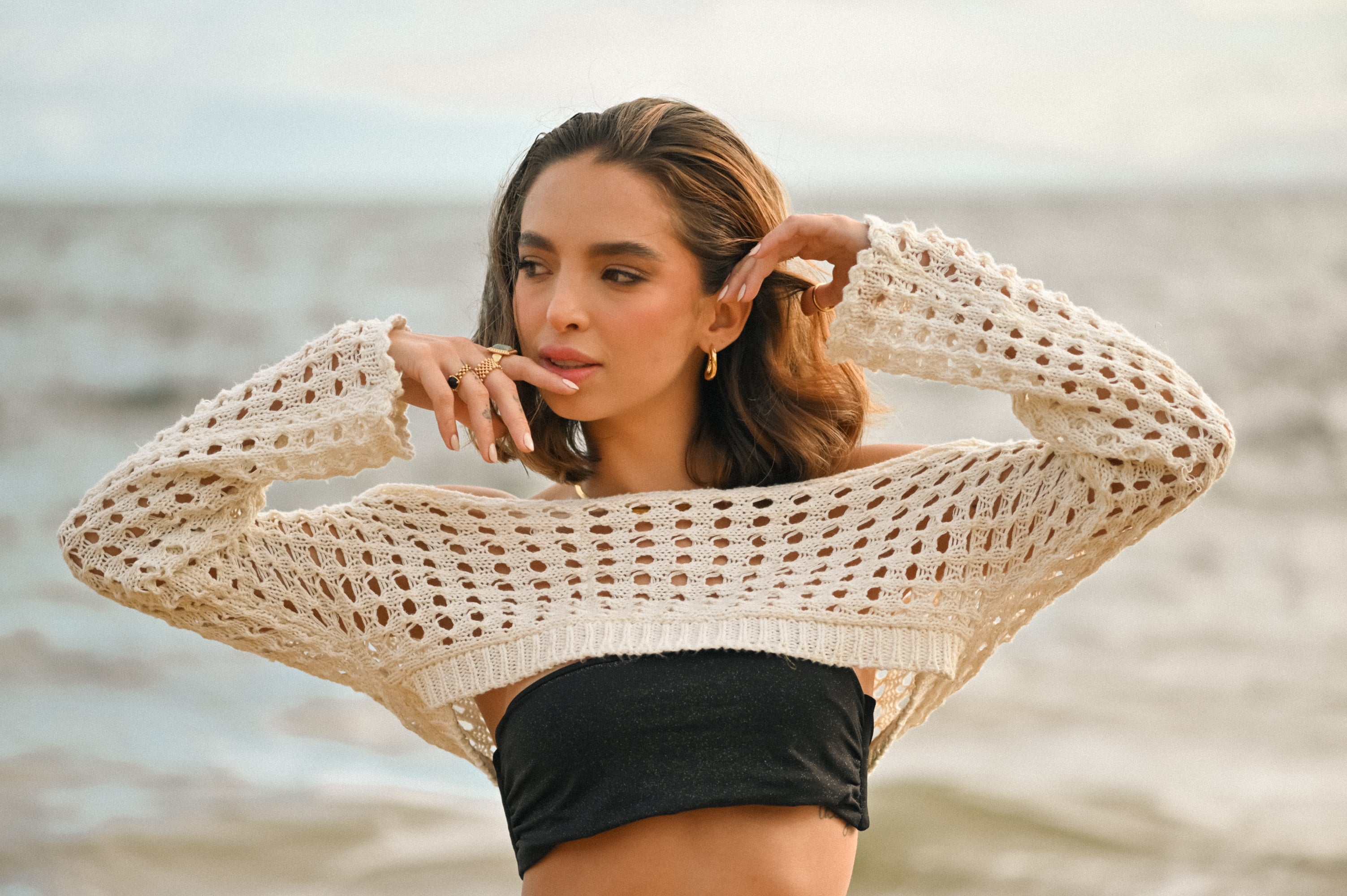 Model wearing Wavy Square Hoop Earrings in gold by Mila Online Shop, styled with stacked rings. Showcasing a bold square shape and lightweight elegance. Fashion-forward hoop earrings Australia.