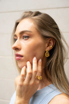 Model wearing gold Click Stud Earrings styled with a matching ear cuff – bold and elegant statement studs for a refined everyday look.