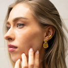 Model wearing gold Click Stud Earrings styled with hammered ear cuff – bold and elegant statement studs for a refined everyday look.