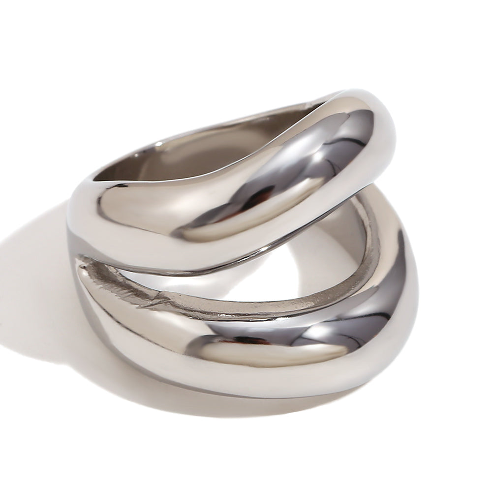 Close up of Mila Online Shop Maxi Ring in silver with sculptural chunky shape, modern statement ring styled with gold stackable rings.