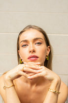 Model wearing vivid green Mia Resin Hoops by Mila Online Shop, styling bangles and rings for a cohesive, fashion-forward jewellery look.